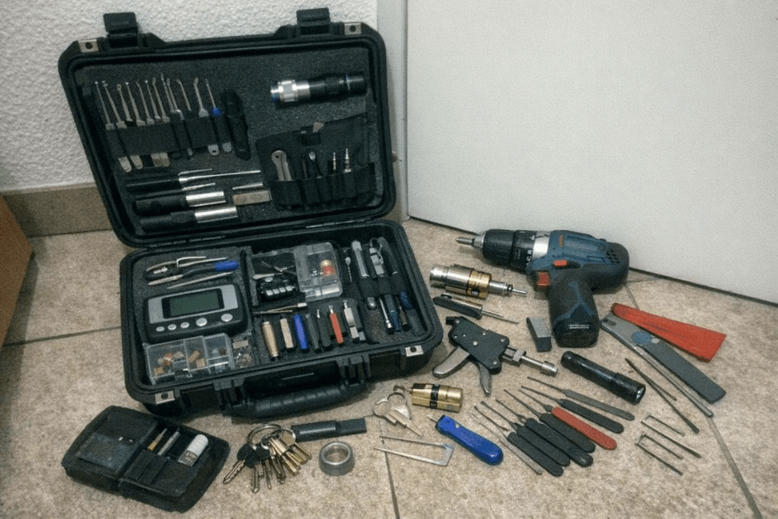 Auf einer Werkbank liegen Profilzylinder, Schrauben und ein Messschieber neben einer Stirnlampe